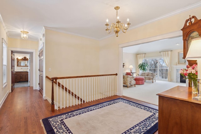 hall featuring wood-type flooring, crown molding, and a chandelier