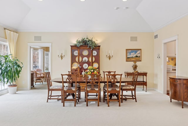 dining area with vaulted ceiling, ornamental molding, and light colored carpet