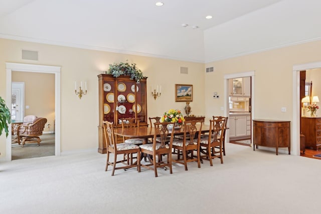 dining space with crown molding, lofted ceiling, and light carpet