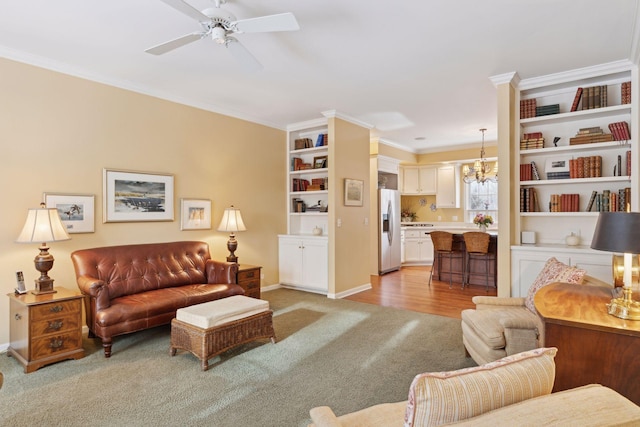 carpeted living room with ornamental molding and ceiling fan with notable chandelier