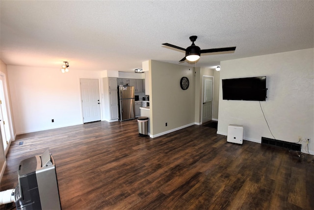 313 10th Ave NE, Roseau, MN 56751 - unfurnished living room featuring dark wood-style flooring, a textured ceiling, baseboards, and a ceiling fan