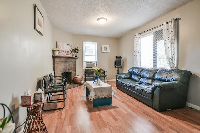 living room featuring hardwood / wood-style flooring, a fireplace, a wealth of natural light, and a textured ceiling