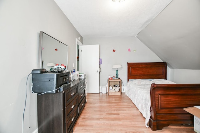 bedroom featuring lofted ceiling and light hardwood / wood-style floors