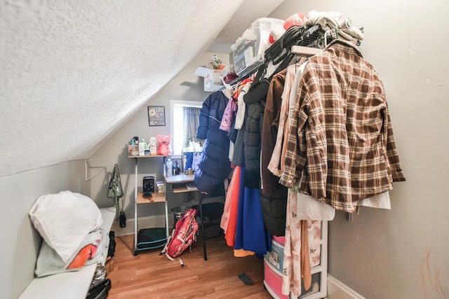 walk in closet featuring hardwood / wood-style floors and vaulted ceiling