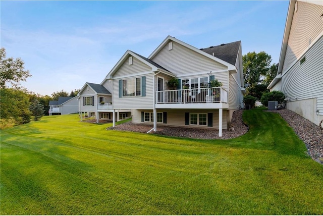 back of property with a deck, a yard, and central AC