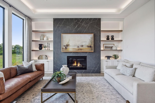 living room with light hardwood / wood-style flooring, a fireplace, and built in shelves