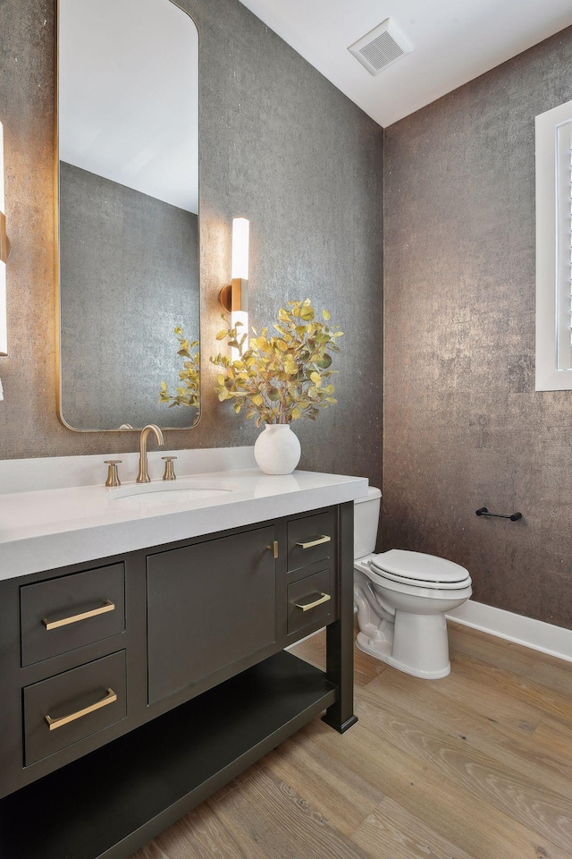 bathroom with vanity, hardwood / wood-style floors, and toilet