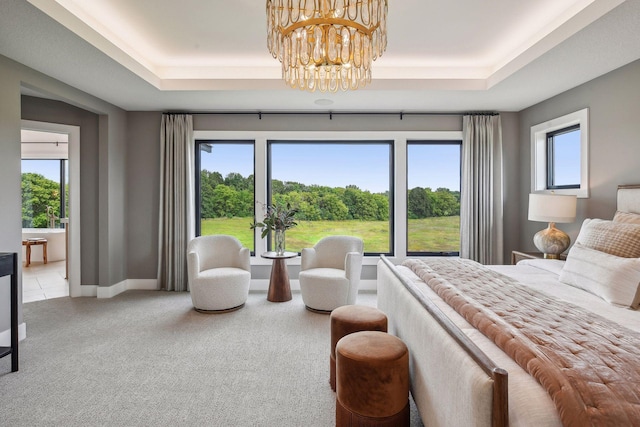 carpeted bedroom with a notable chandelier and a raised ceiling