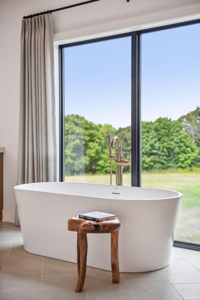 interior space with a bath and tile patterned flooring