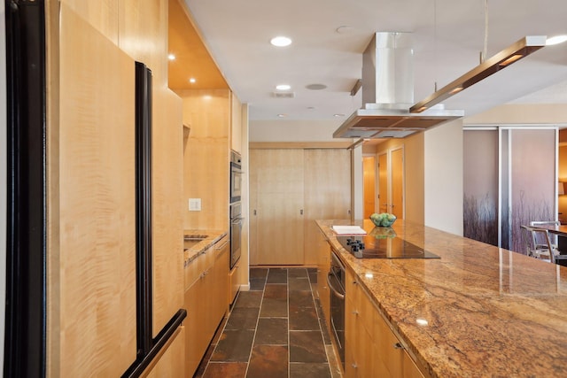 kitchen featuring light stone counters, island range hood, stainless steel fridge, and black electric stovetop