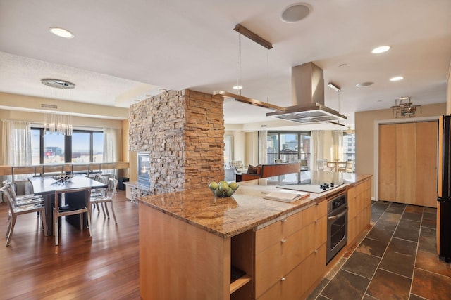 kitchen featuring pendant lighting, island exhaust hood, dark wood-type flooring, stainless steel oven, and black electric cooktop