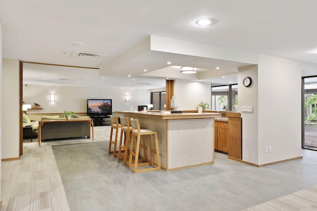 kitchen with a kitchen island, plenty of natural light, and a breakfast bar area