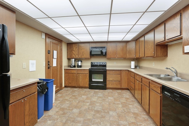 kitchen featuring a paneled ceiling, black appliances, and sink