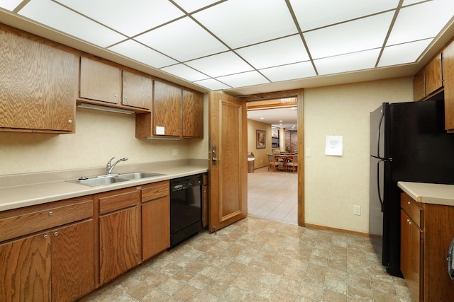 kitchen featuring black appliances, a paneled ceiling, and sink