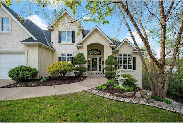 view of front of house with french doors, a front yard, and a garage