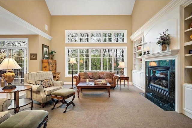 interior space featuring carpet floors, built in shelves, a high end fireplace, and high vaulted ceiling