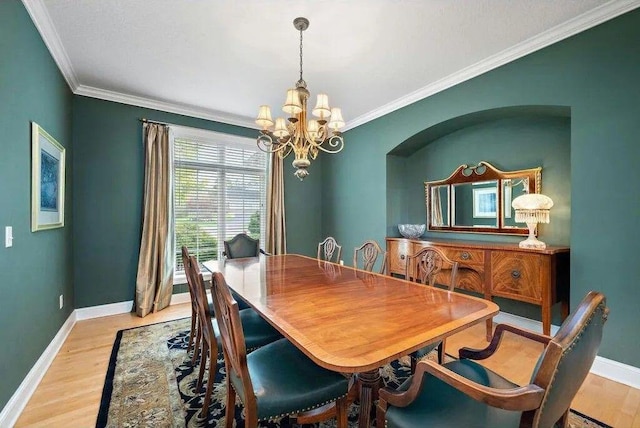 dining room with crown molding, a chandelier, and light wood-type flooring