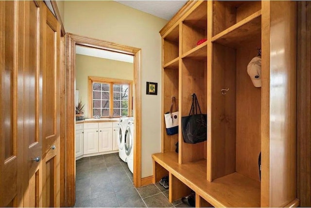 mudroom with independent washer and dryer and dark tile patterned floors