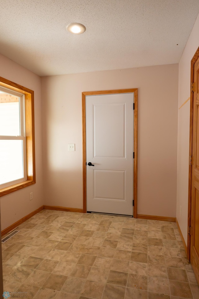 unfurnished room featuring a textured ceiling