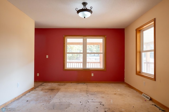 unfurnished room with a textured ceiling