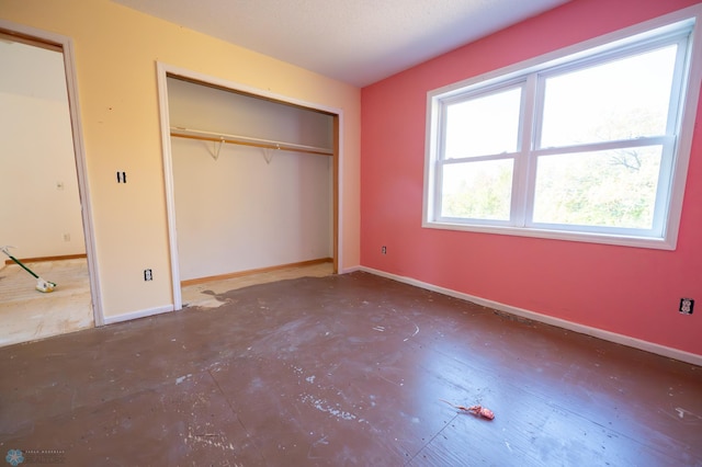 unfurnished bedroom with a closet and multiple windows