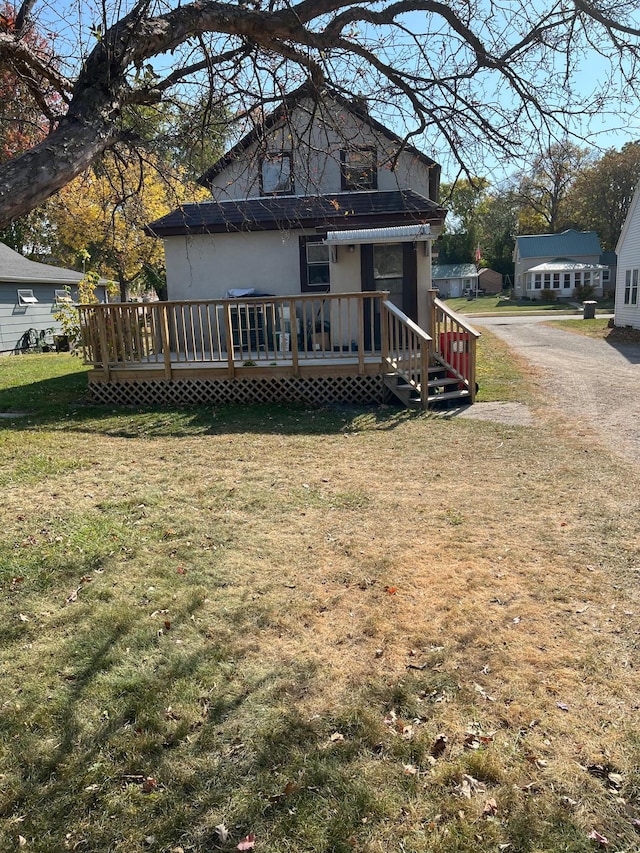 back of house featuring a wooden deck and a lawn