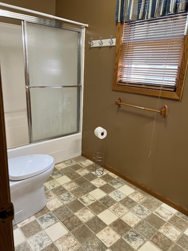 721 5th Ave E, Alexandria, MN 56308 - bathroom featuring stone finish flooring and bath / shower combo with glass door