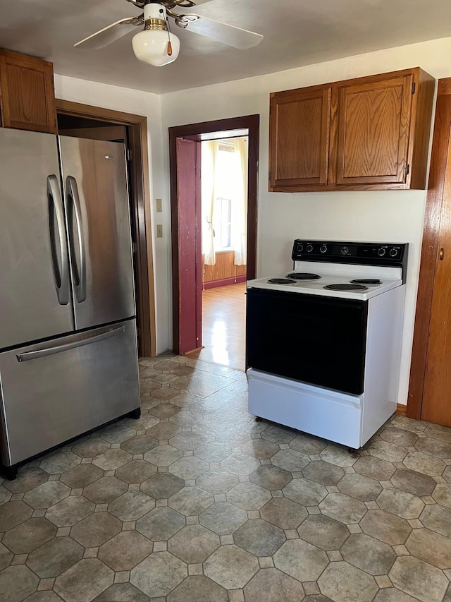 721 5th Ave E, Alexandria, MN 56308 - kitchen with freestanding refrigerator, white range with electric stovetop, ceiling fan, and brown cabinetry