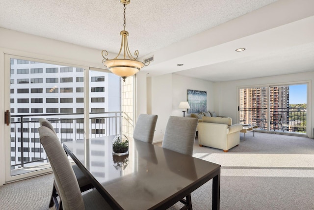 dining area featuring a textured ceiling and carpet flooring