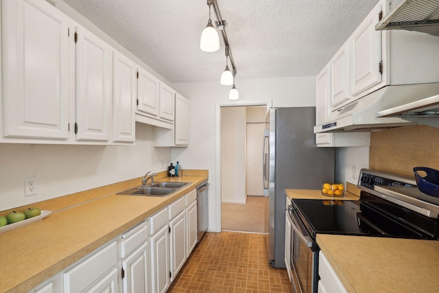 kitchen with pendant lighting, appliances with stainless steel finishes, sink, and white cabinetry