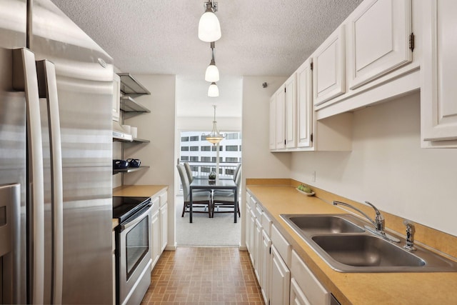 kitchen with hanging light fixtures, sink, stainless steel appliances, and white cabinets