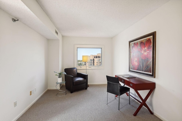 carpeted home office featuring a textured ceiling