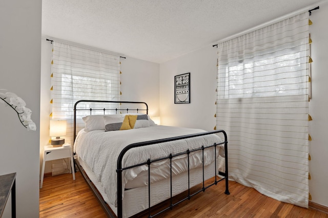 bedroom with wood-type flooring and a textured ceiling