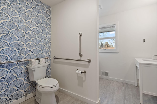 bathroom with hardwood / wood-style flooring, vanity, and toilet