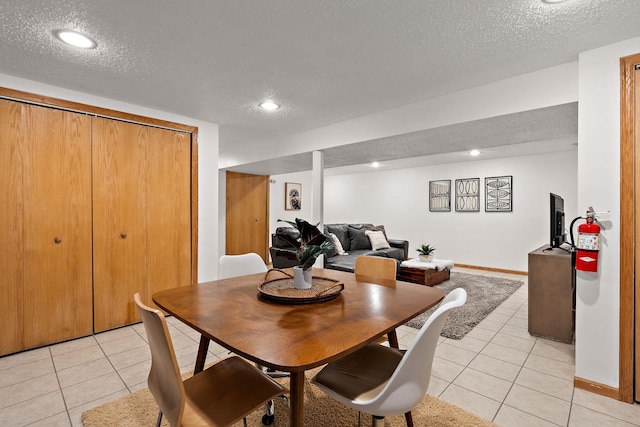 tiled dining room with a textured ceiling