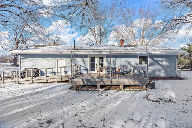 snow covered rear of property featuring a wooden deck