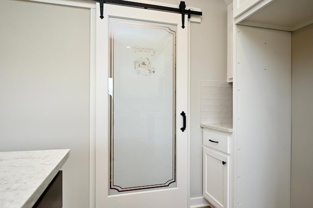 interior space with a barn door and decorative backsplash