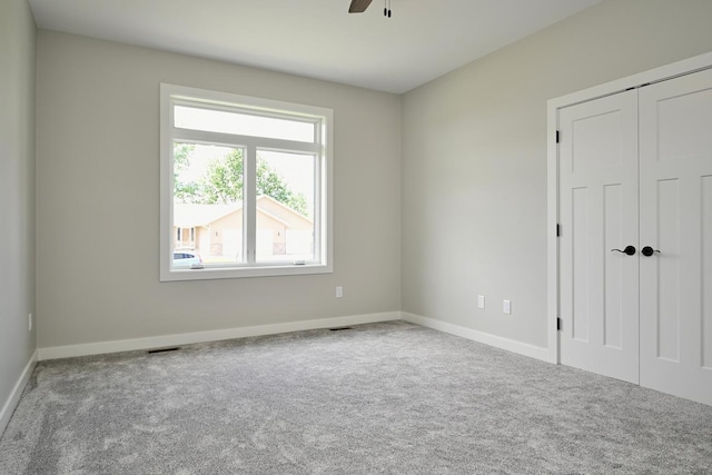 empty room featuring carpet flooring and ceiling fan