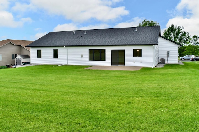 rear view of property featuring a lawn, a patio area, and central AC