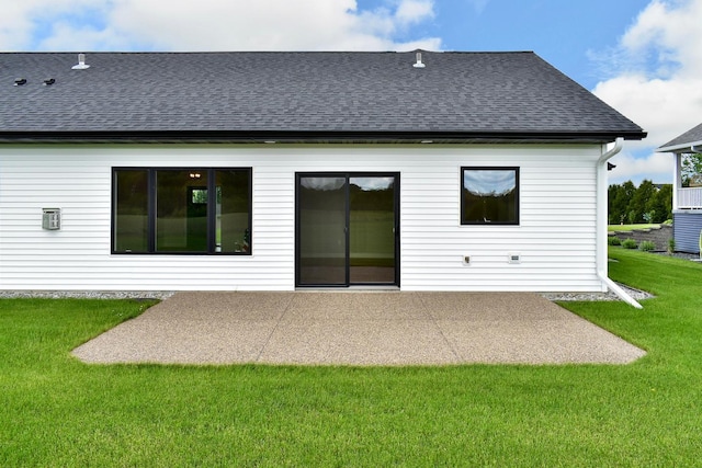 rear view of property featuring a patio and a lawn