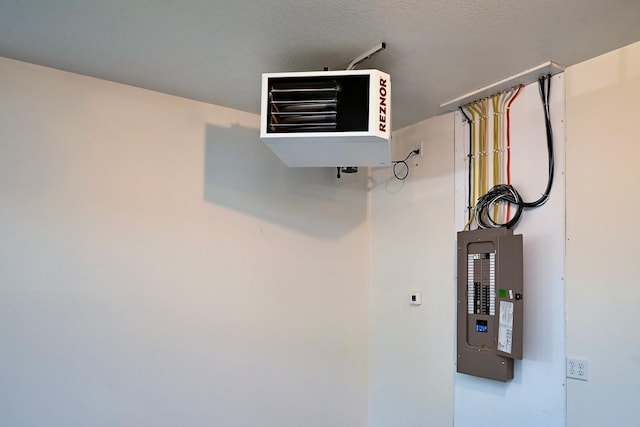 interior details featuring electric panel and a textured ceiling