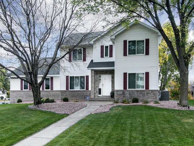 view of front of house featuring central air condition unit, a front lawn, and brick siding