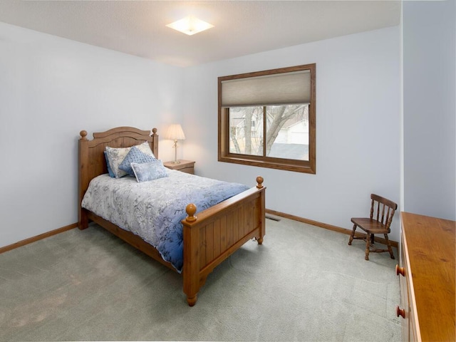 bedroom with light colored carpet and baseboards