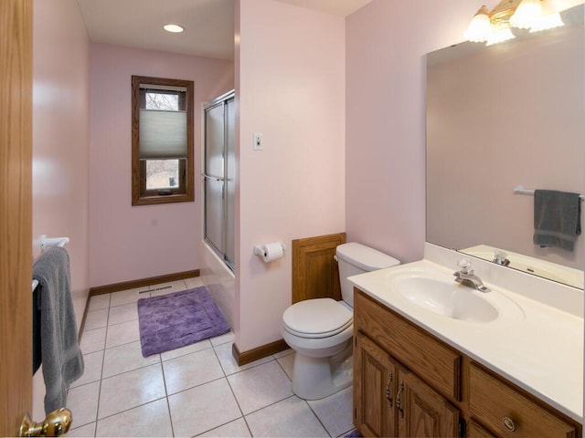 bathroom featuring bath / shower combo with glass door, baseboards, toilet, tile patterned flooring, and vanity