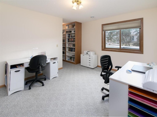 office space with baseboards and light colored carpet