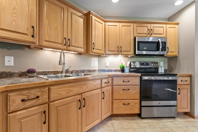 kitchen featuring stainless steel appliances, sink, and light tile patterned flooring