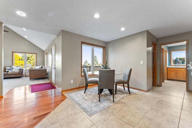 tiled dining space featuring lofted ceiling