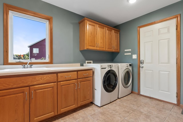 washroom featuring sink, light tile patterned floors, cabinets, and separate washer and dryer