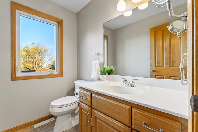 bathroom with vanity, toilet, a wealth of natural light, and tile patterned flooring