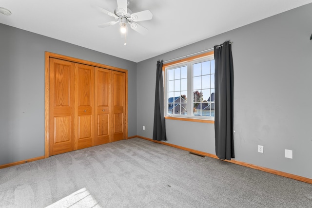 unfurnished bedroom with a closet, ceiling fan, and light colored carpet